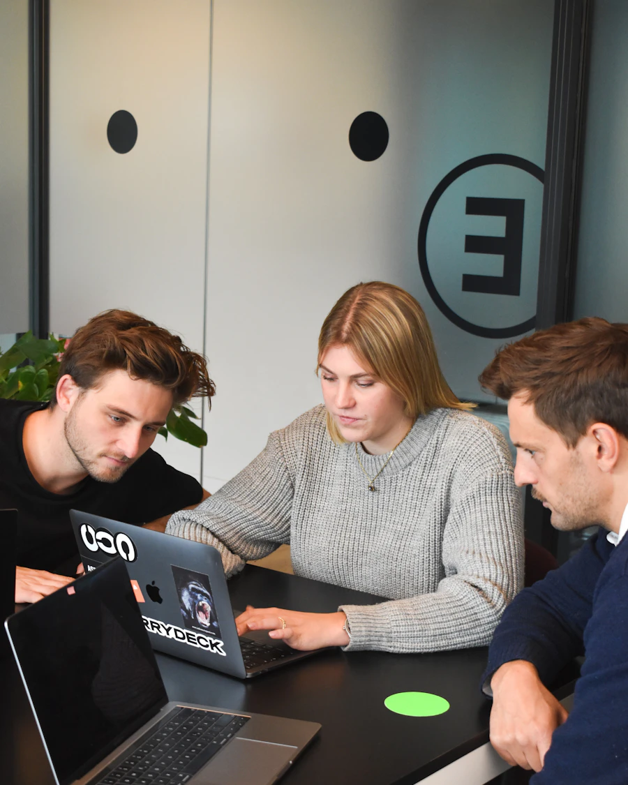 Equipe trabalhando junta em volta de um notebook